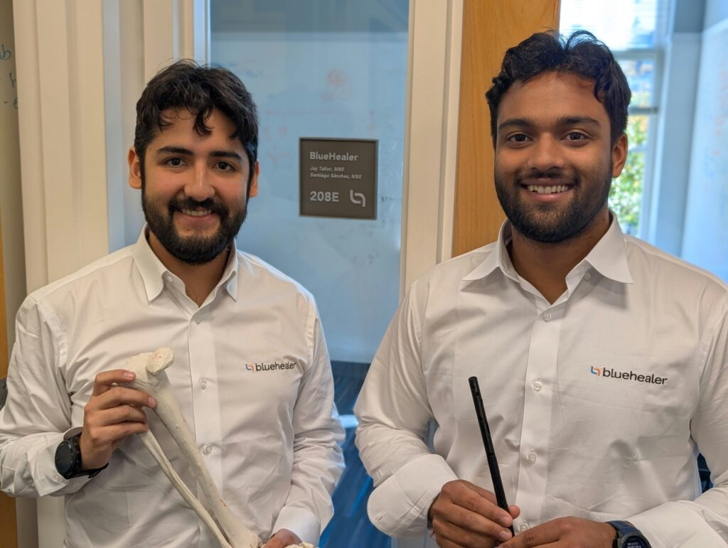 BlueHealer co-founders Santiago Sánchez Rentería and Jay Tailor holding a tibia bone model outside their lab